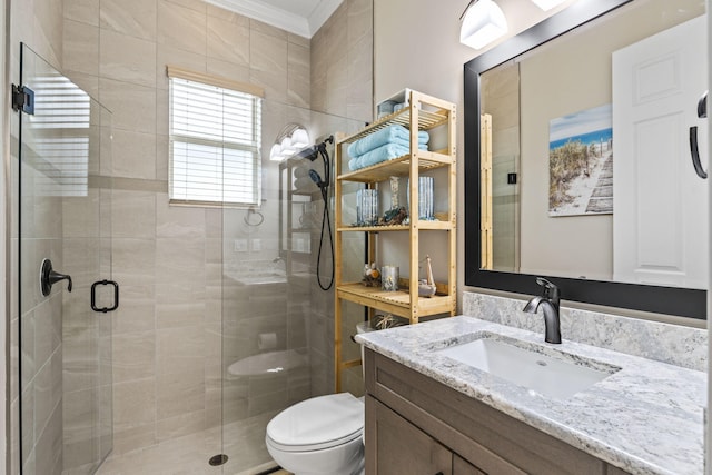 bathroom with crown molding, vanity, toilet, and a shower with shower door