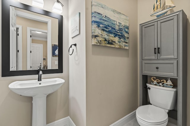 bathroom featuring ornamental molding and toilet