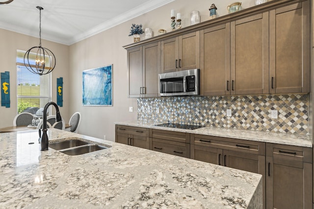 kitchen with ornamental molding, sink, light stone counters, and black electric cooktop