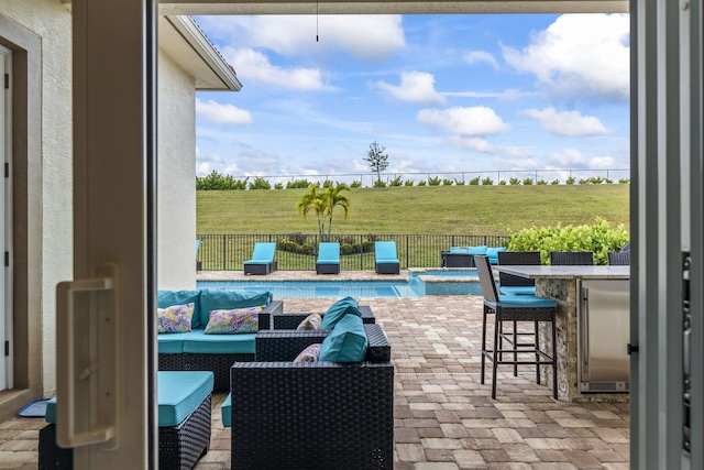 view of patio / terrace featuring an outdoor living space, an outdoor bar, a fenced in pool, and a rural view