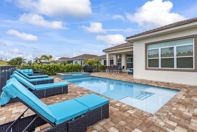 view of swimming pool with an in ground hot tub, grilling area, an outdoor hangout area, and a patio