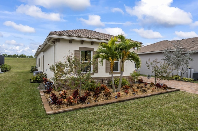 view of side of home with a yard and central air condition unit