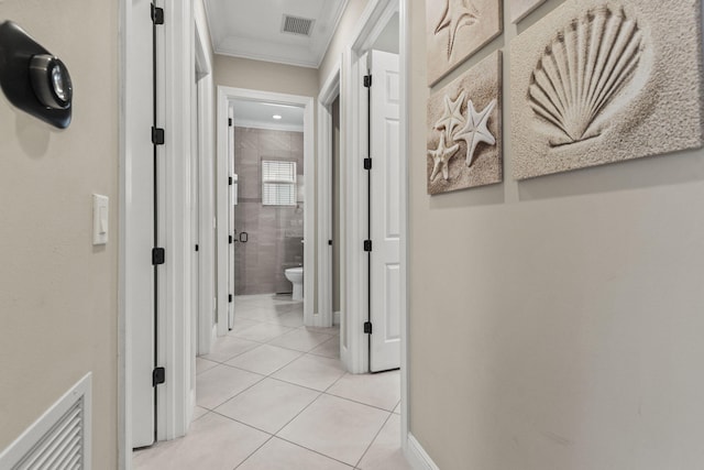 corridor featuring crown molding and light tile patterned flooring