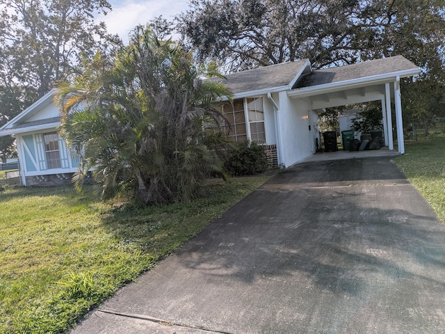 view of side of property with a carport and a yard