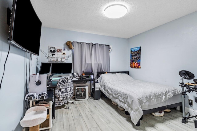 bedroom with hardwood / wood-style flooring and a textured ceiling