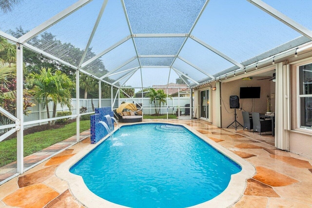 view of swimming pool featuring pool water feature, a lanai, and a patio