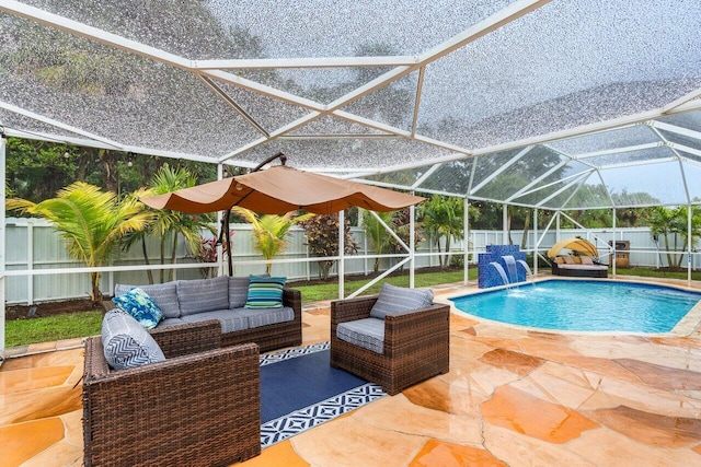 view of pool featuring glass enclosure, a patio area, outdoor lounge area, and pool water feature