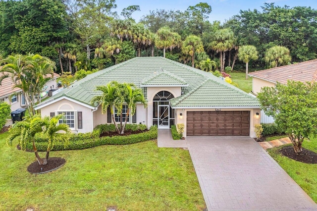 mediterranean / spanish-style home with a garage and a front lawn