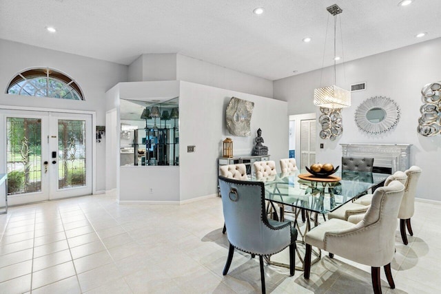 tiled dining area featuring a textured ceiling, a towering ceiling, and french doors