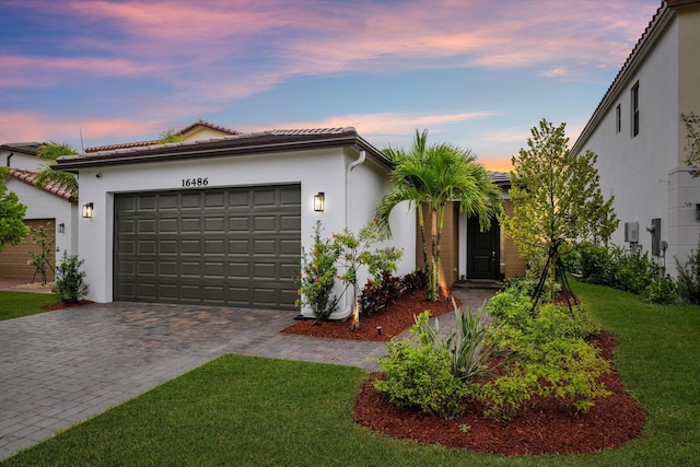 view of front facade with a garage and a yard