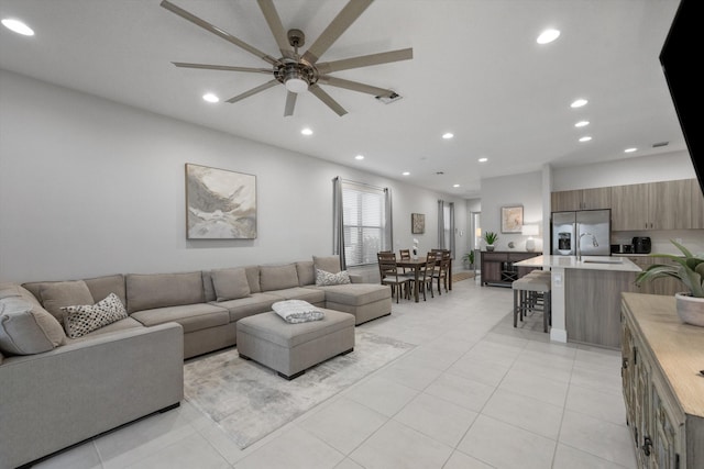 living room with ceiling fan, sink, and light tile patterned floors