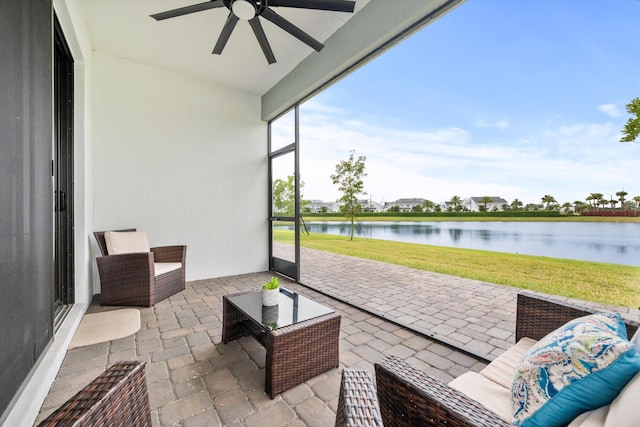 sunroom with a water view and ceiling fan