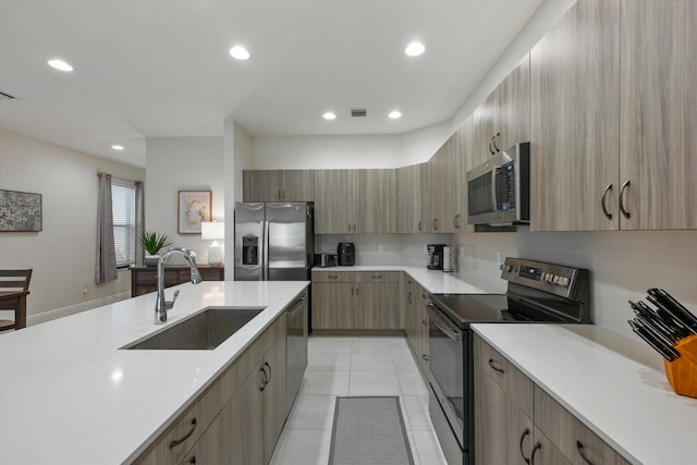 kitchen with sink, stainless steel appliances, and light tile patterned floors