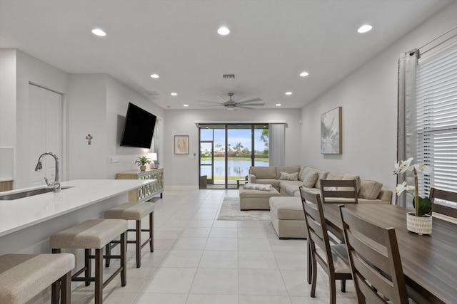 tiled living room featuring ceiling fan and sink