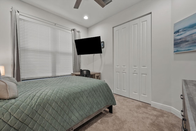 bedroom with light carpet, a closet, and ceiling fan