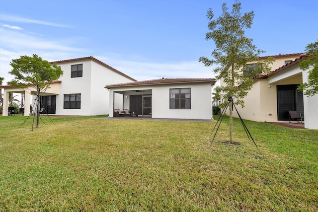 rear view of property featuring a lawn