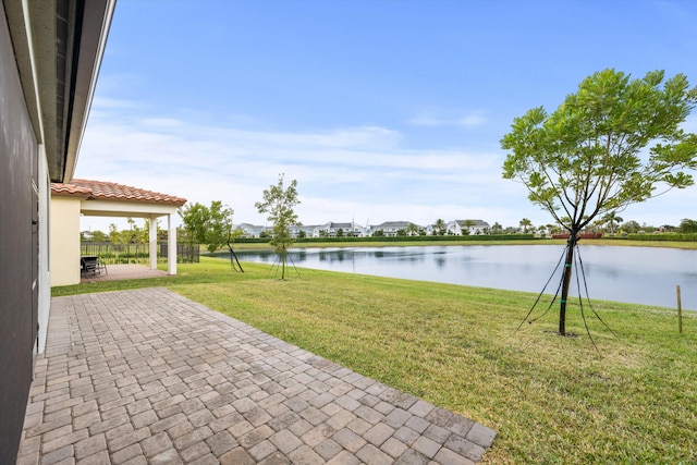 view of yard with a water view and a patio