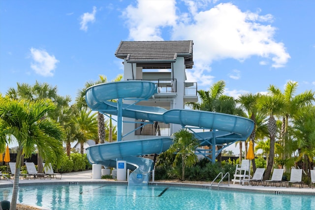 view of pool with a water slide and a patio