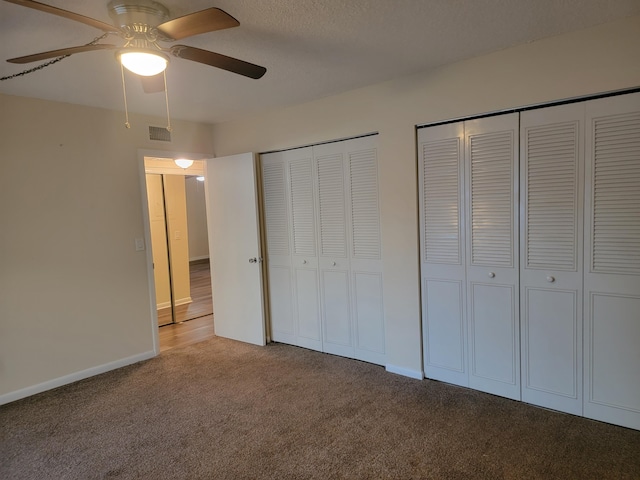 unfurnished bedroom with ceiling fan, carpet, and multiple closets