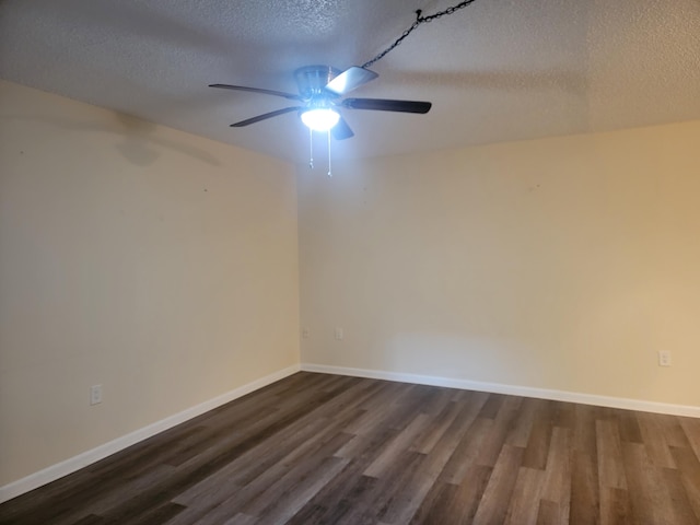 spare room featuring a textured ceiling and dark hardwood / wood-style floors