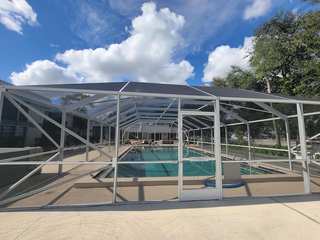 view of swimming pool featuring a lanai