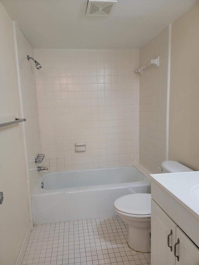 full bathroom with toilet, tiled shower / bath, tile patterned floors, and vanity