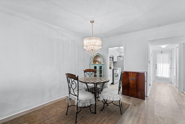 dining space featuring light wood-type flooring, a notable chandelier, crown molding, and a textured ceiling