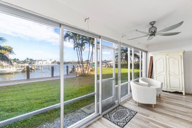 sunroom / solarium with a water view and ceiling fan