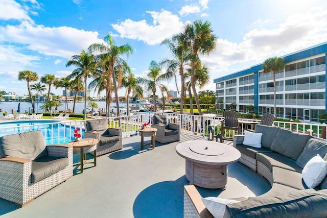 view of patio / terrace with a water view, an outdoor living space, and a community pool