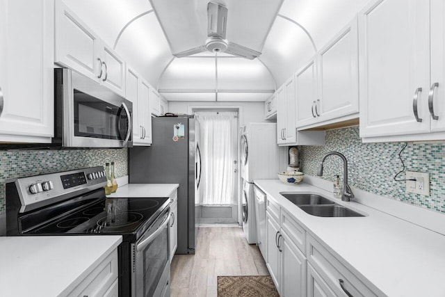 kitchen with range hood, stainless steel appliances, white cabinets, and sink