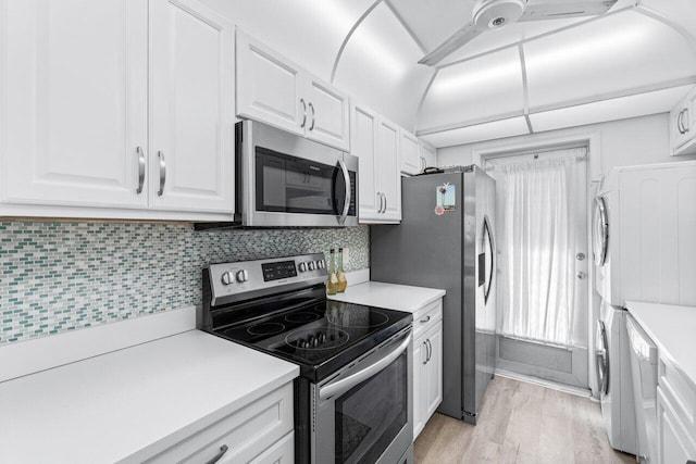 kitchen featuring light wood-type flooring, stainless steel appliances, white cabinets, and tasteful backsplash