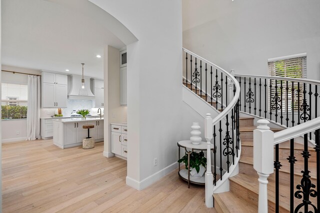 stairway featuring hardwood / wood-style floors and sink