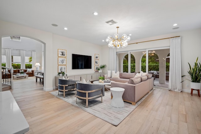 living room with a notable chandelier and light wood-type flooring