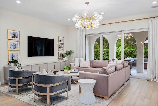 living room with a notable chandelier and light wood-type flooring