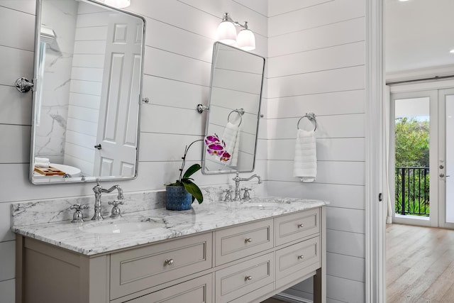 bathroom featuring hardwood / wood-style flooring, vanity, and wooden walls