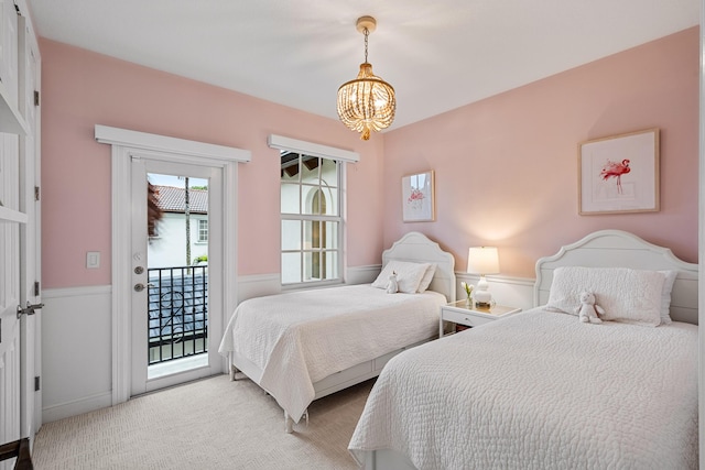 bedroom with light carpet, access to outside, and an inviting chandelier