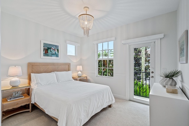 carpeted bedroom featuring an inviting chandelier and access to outside