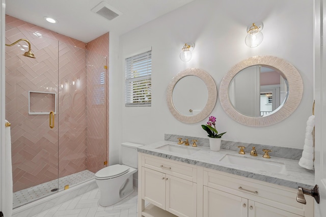 bathroom with vanity, toilet, and a tile shower