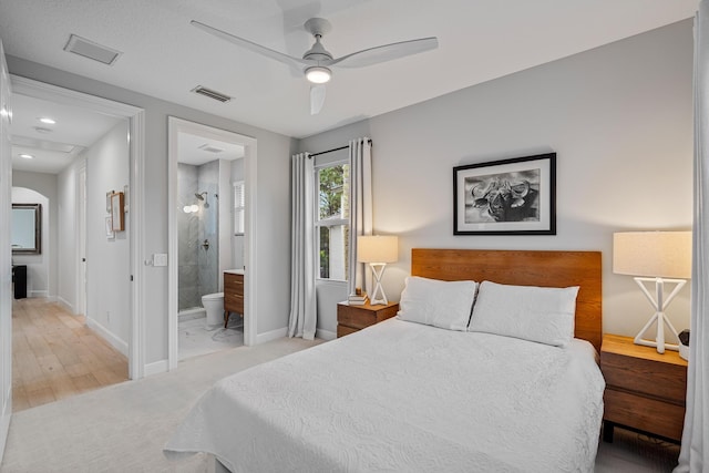 bedroom featuring ceiling fan, connected bathroom, and light hardwood / wood-style flooring