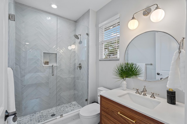 bathroom featuring vanity, an enclosed shower, and toilet