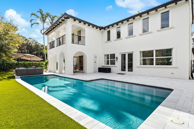 view of swimming pool with outdoor lounge area, a yard, french doors, and a patio