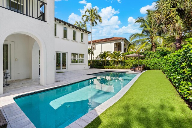 view of swimming pool featuring a yard and a patio area