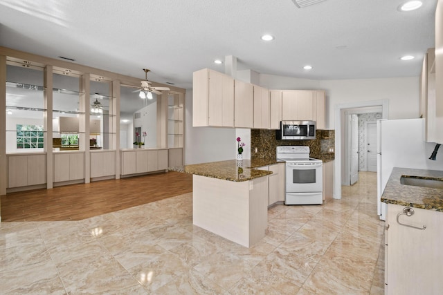 kitchen featuring kitchen peninsula, ceiling fan, backsplash, white electric range, and dark stone countertops