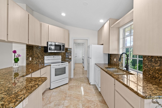 kitchen featuring sink, white appliances, tasteful backsplash, and dark stone countertops