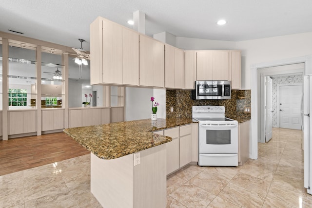 kitchen with a textured ceiling, white appliances, dark stone countertops, kitchen peninsula, and ceiling fan