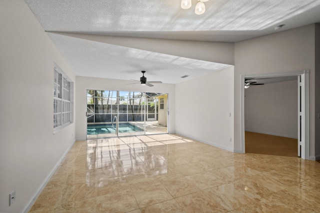 interior space with a textured ceiling, ceiling fan, and vaulted ceiling