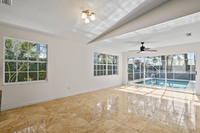 interior space with a textured ceiling, ceiling fan, and lofted ceiling