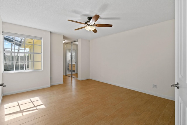 empty room featuring ceiling fan, a textured ceiling, and light hardwood / wood-style flooring