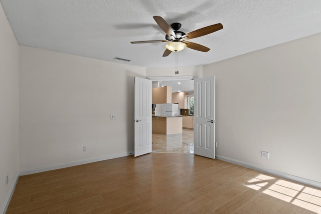 spare room with ceiling fan and light hardwood / wood-style flooring