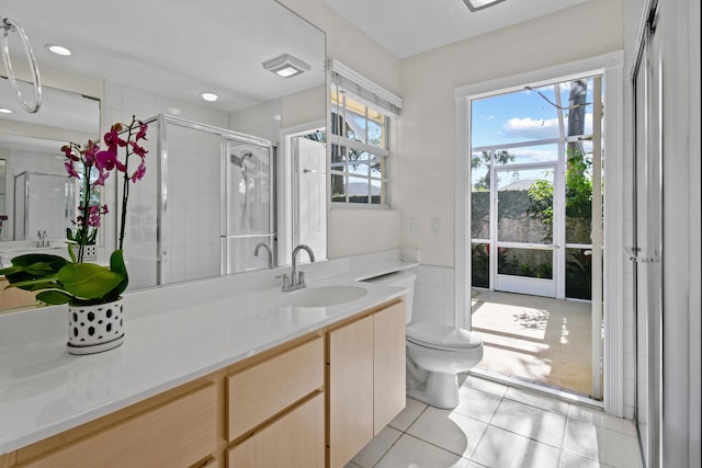 bathroom featuring a shower with shower door, tile patterned floors, vanity, and toilet